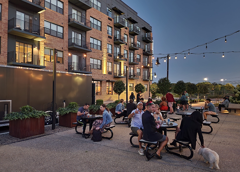 Residents sitting outside at tables enjoying Oktoberfest at Steel Works Apartments